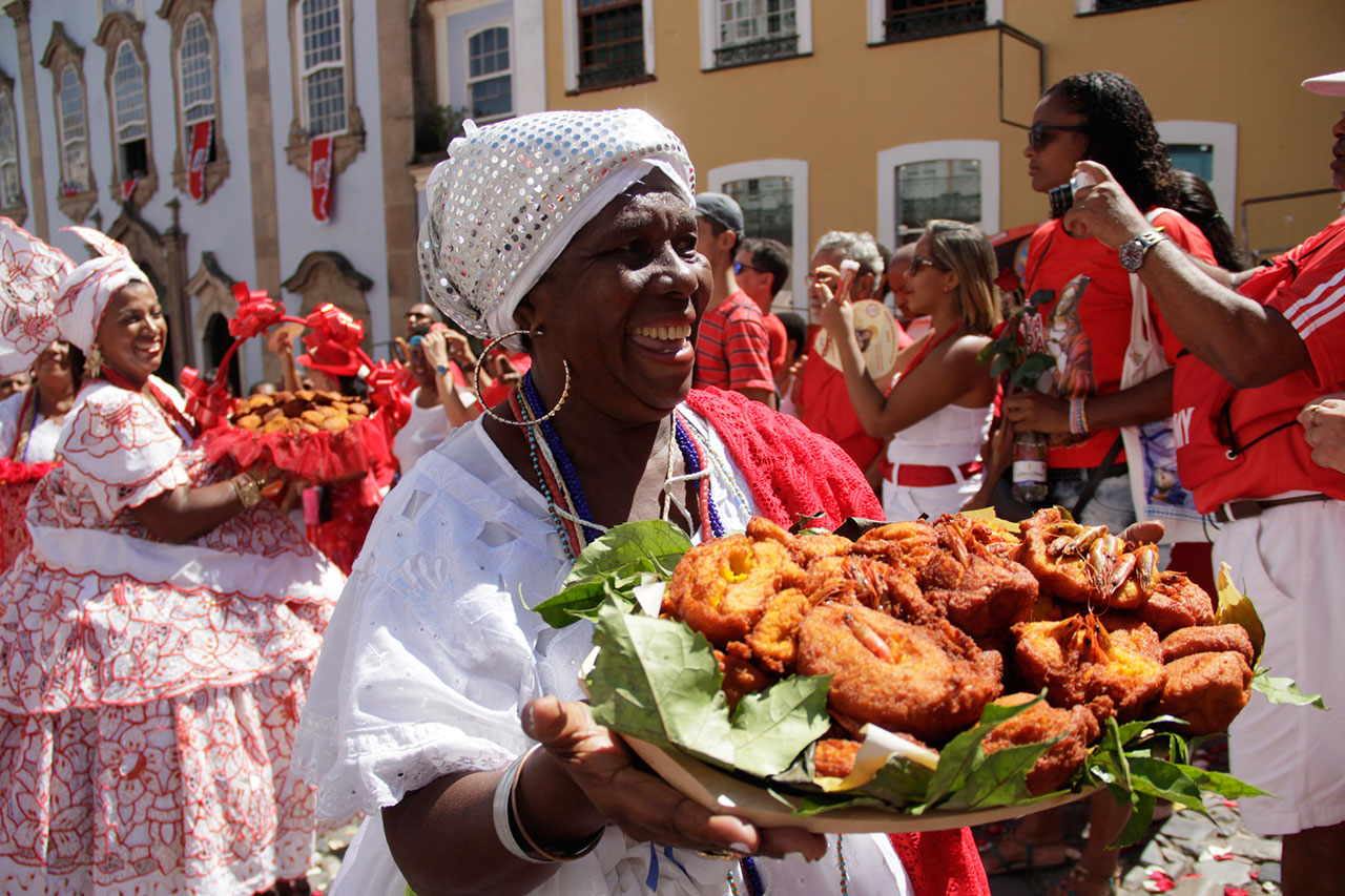 Baiana carregando acarajé que é um dos pratos típicos da Bahia